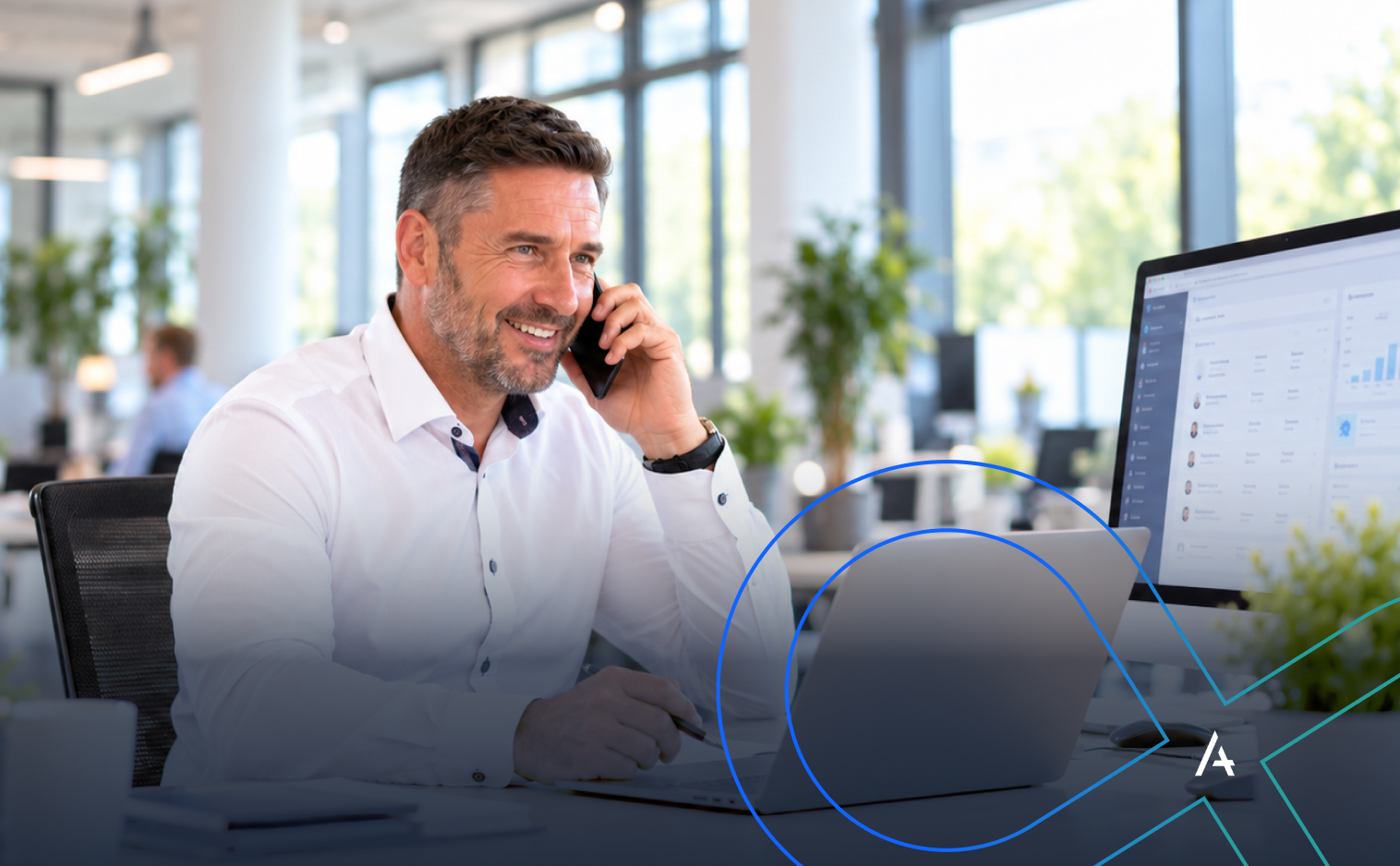 Vertriebsmitarbeiter telefoniert mit einem Kunden an seinem Arbeitsplatz im modernen Büro. Auf dem Bildschirm ist ein CRM-System zu sehen.